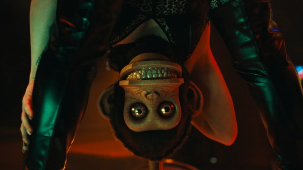 A toy monkey grins upside down in "The Monkey."