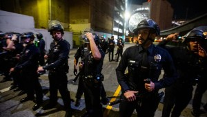 Police officers in riot gear monitor the crowd during an Anti-ICE demonstration in Los Angeles on August 8, 2025. The protest draws attention to controversial immigration enforcement policies and calls for the abolition of ICE