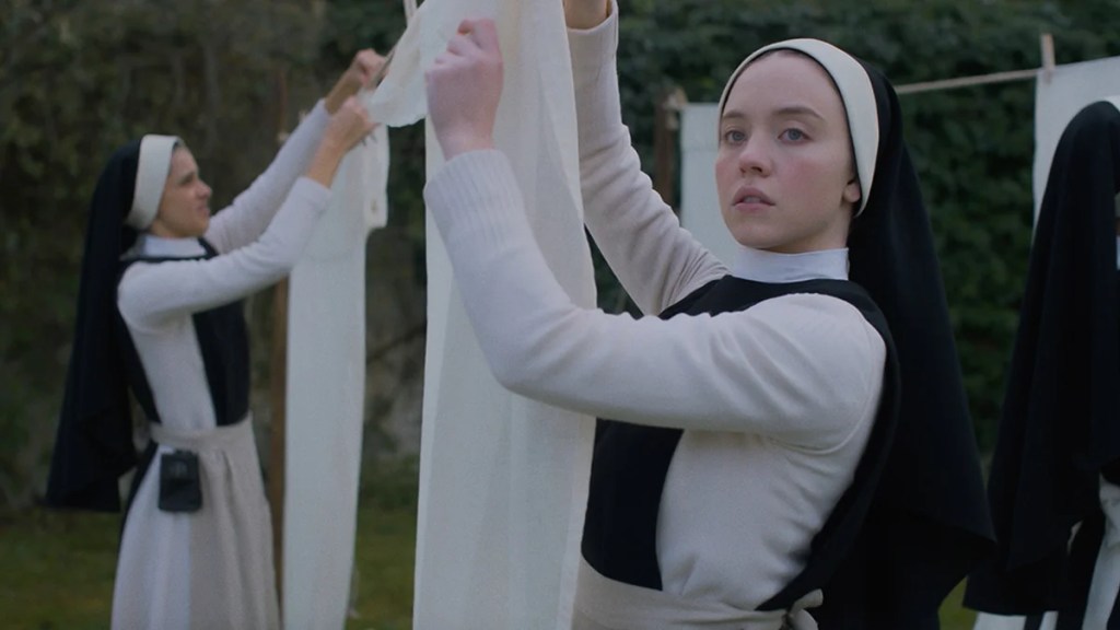 Sydney Sweeney, a woman with light-toned skin, dressed as a nun with other nuns in the background in "Immaculate."