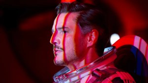 Pedro Pascal wears a spacesuit with dramatic red and white lights falling across his face