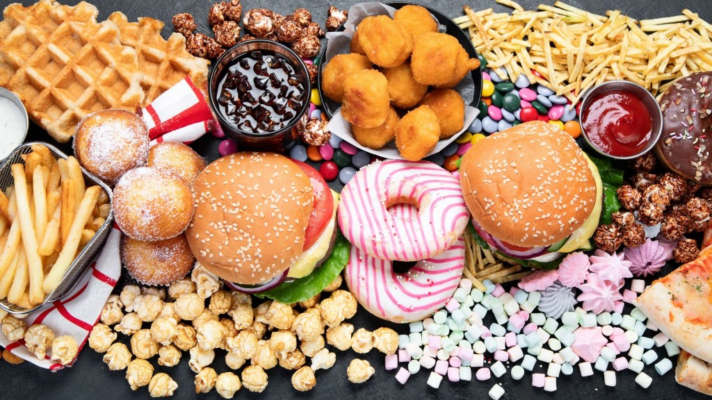 Unhealthy products. food bad for figure, skin, heart and teeth. Assortment of fast carbohydrates food with fries and cola on a dark background. Top view. (Getty Images)
