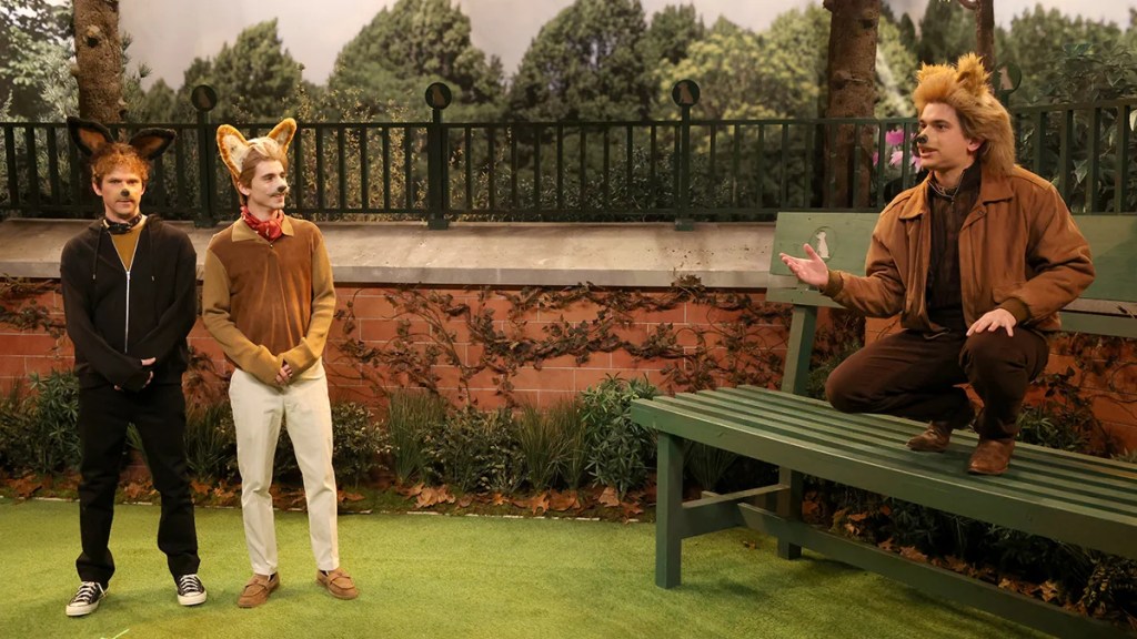 Left to right: Mikey Day as Pogo, host Timothée Chalamet as Biscuit, and Andrew Dismukes as Taco. All are dressed as dogs at a scaled up dog park