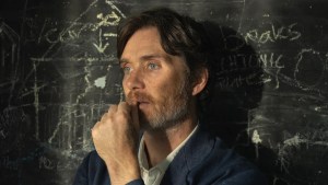 Cillian Murphy stands in front of a chalkboard